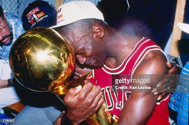 Guard Michael Jordan of the Chicago Bulls sits nexts to his wife Juanita and his dad James while hugging the NBA Championship Trophy after the Bulls...