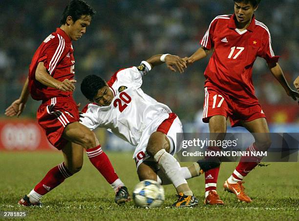 Indonesian striker Bambang Panungkas tries to pass between Vietnamese Vu Duy Hoang and Dang Thanh Phuong during a qualyfying soccer match in the...