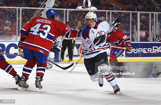 Left wing Ales Hemsky of the Edmonton Oilers skates by defenseman Patrice Brisebois of the Montreal Canadiens at the Molson Canadien Heritage Classic...