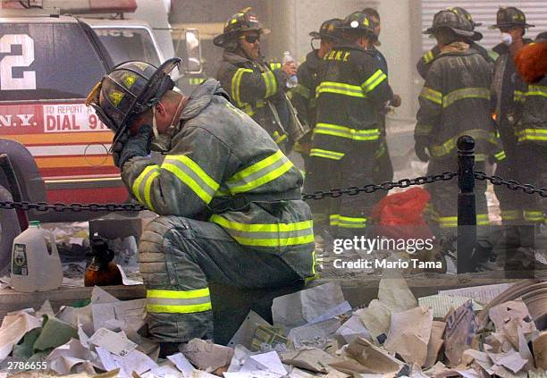 Firefighter Gerard McGibbon, of Engine 283 in Brownsville, Brooklyn, prays after the World Trade Center buildings collapsed September 11, 2001 after...