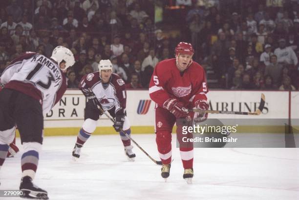 Defenseman Nicklas Lidstrom of the Detroit Red Wings moves the puck as Colorado Avalanche leftwinger Valeri Kamensky and rightwinger Keith Jones...