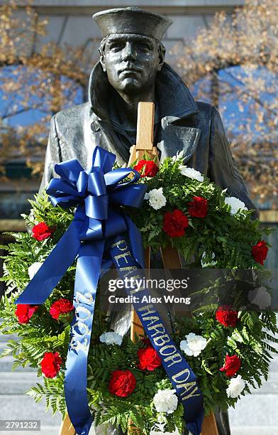 Wreath to memorialize the victims of the attack on Pearl Harbor and pay tribute to the veterans of World War II is placed in front of the Lone Sailor...