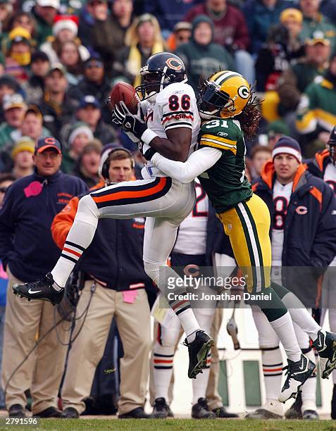 Receiver Marty Booker of the Chicago Bears hauls in a pass in front of cornerback Al Harris of the Green Bay Packers during a game on December 7,...