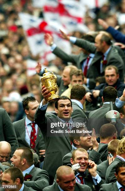 Captain of the England rugby team, Martin Johnson holds the William Webb Ellis trophy aloft during the England Rugby World Cup team victory parade...