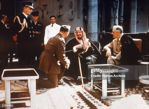 American president Franklin Delano Roosevelt meets with King Ibn Saud of Saudi Arabia, chief of staff William D. Leahy and Col. William A. Eddy ,...