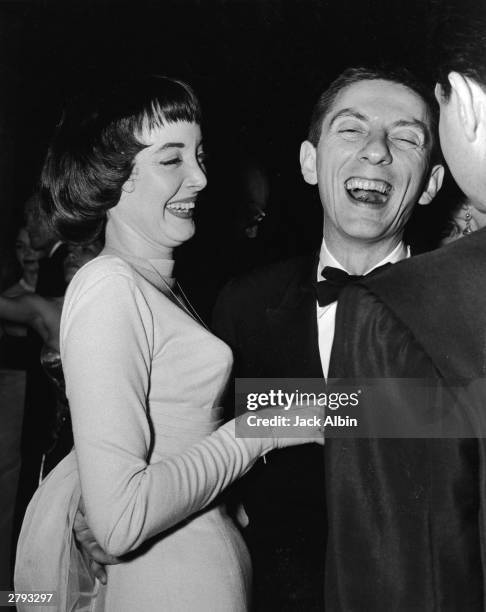 American actress Carolyn Jones and husband, American producer and writer Aaron Spelling laugh at a party, circa 1960.