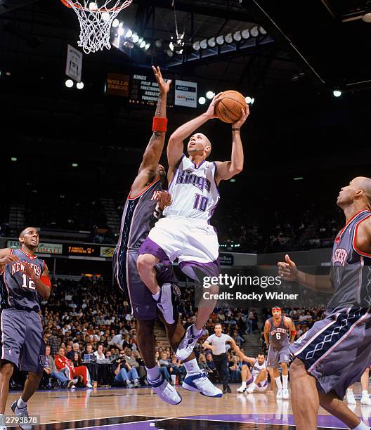 Mike Bibby of the Sacramento Kings takes the ball up against Rodney Rogers of the New Jersey Nets during the NBA game at Arco Arena on November 30,...