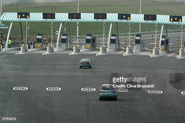 Cars approach the new M6 motorway toll booths on December 9, 2003 in Birmingham, England. This marks the opening of the first phase of the dual...