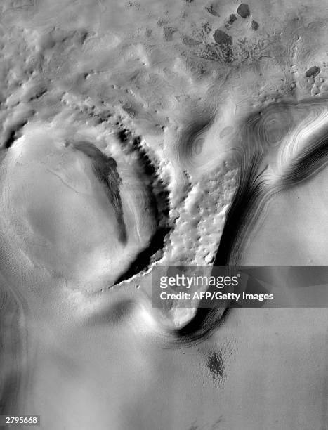 This NASA Mars Odyssey Spacecraft image released 09 December, 2003 shows layered deposits covering older, cratered surfaces near Mars' south pole....