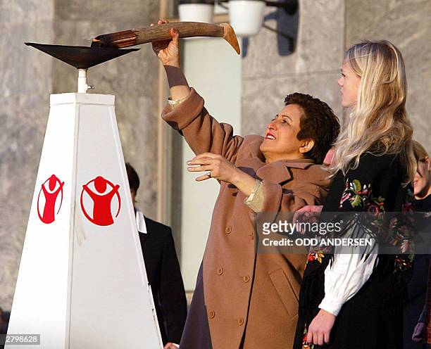 Iranian human rights activist Shirin Ebadi lights the Save the Children peace flame as 4000 children greeted her outside Oslo's city hall before the...