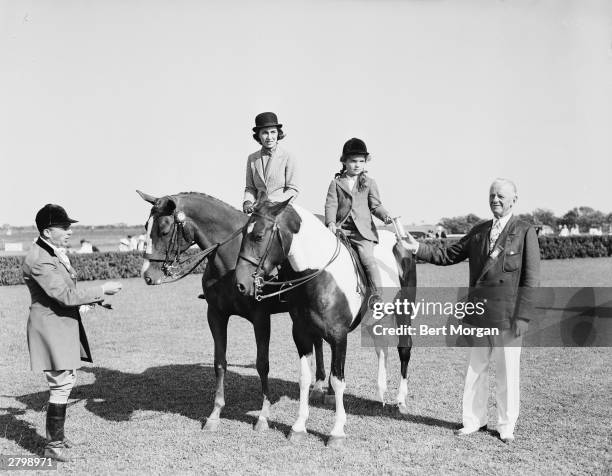 Janet Lee Bouvier with her daughter Jacqueline Bouvier , who accepts the 'Family Class' trophy from Albert Pardridge at the East Hampton Horse Show,...