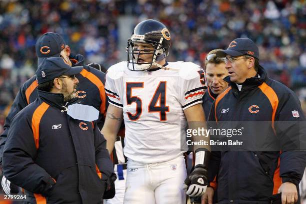 Linebacker Brian Urlacher of the Chicago Bears talks with trainers during the game against the Denver Broncos on November 23, 2003 at Invesco Field...