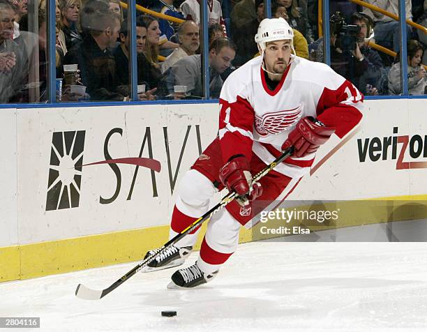 Mathieu Dandenault of the Detroit Red Wings skates with the puck against the St. Louis Blues during the game at Savvis Center on November 29, 2003 in...