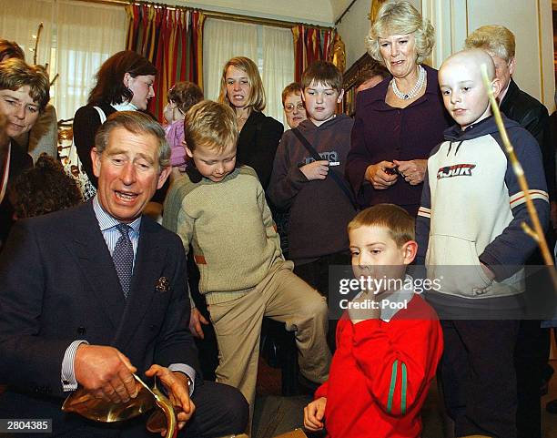 Prince Charles opens gifts at a reception for children suffering from cancer and leukemia at Clarence House as Camilla Parker-Bowles looks on...