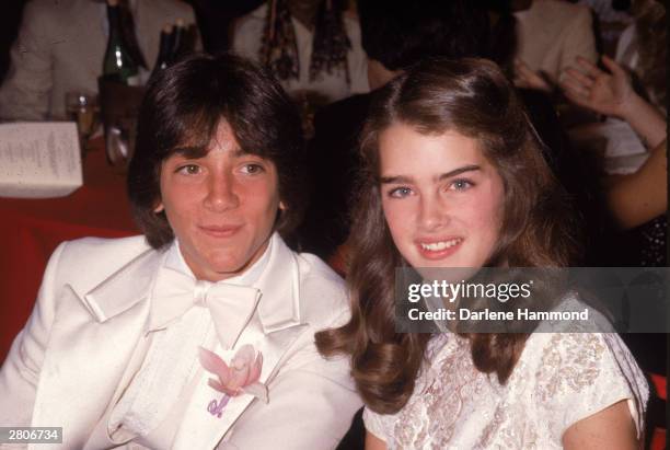 Young American actors Scott Baio and Brooke Shields smile while sitting together at an unidentified event, circa 1978.