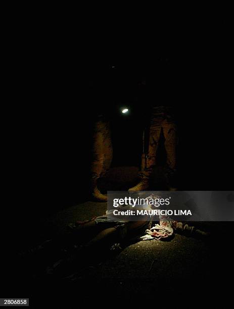 An Iraqi lies dead on the floor with four shots in his head as two US soldiers from 1-22 Battalion of the 4th Infantry Division, who had been...