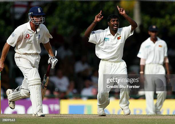 Sri Lankan bowler Muttiah Mralitharan celebrates after taking the wicket of Andrew Flintoff whilst England captain Michael Vaughan looks on during...