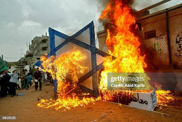 Palestinian supporters of the Islamic Hamas movement burn a Star of David and a coffin symbolizing the so-called Geneva Initiative peace plan during...