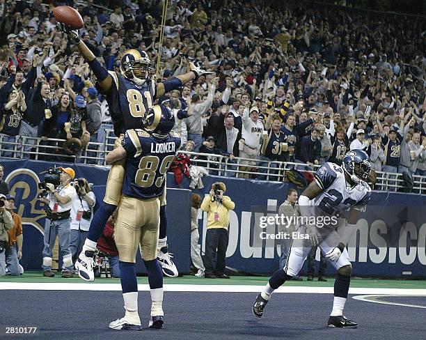 Dane Looker of the St. Louis Rams lifts Torry Holt after Holt caught a touchdown pass in the second quarter against the Seattle Seahawks on December...