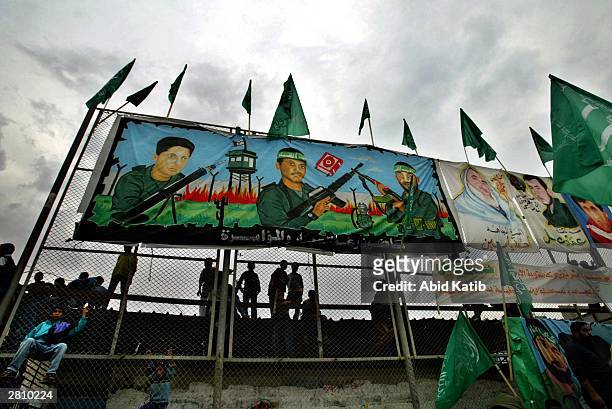 Palestinian children play next to posters of Hamas leaders during a demonstration in the southern Gaza Strip refugee camp of Rafah December 14, 2003...