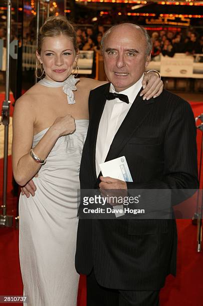 Actress Sienna Miller and Jude Law's father Peter arrive at the UK Royal Charity Premiere of "Cold Mountain" at the Odeon Leicester Square on...