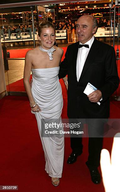 Actress Sienna Miller and Jude Law's father Peter arrive at the UK Royal Charity Premiere of "Cold Mountain" at the Odeon Leicester Square on...