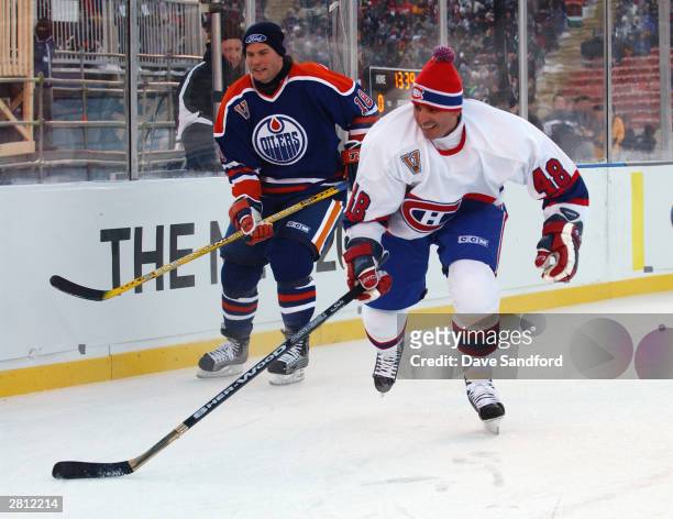 Craig Simpson of the Edmonton Oilers watches as J.J. Daigneault of the Montreal Canadiens chases after the play during the Molson Canadien Heritage...