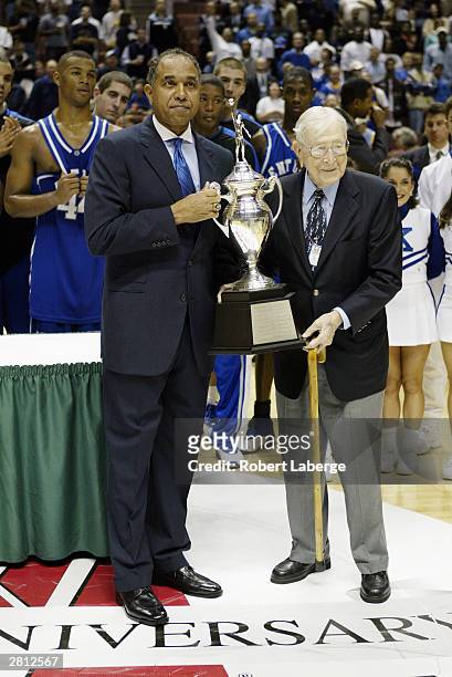 Legendary coach John Wooden awards head coach Tubby Smith of Kentucky the John R. Wooden Classic trophy after defeating UCLA 52-50 in the John R....