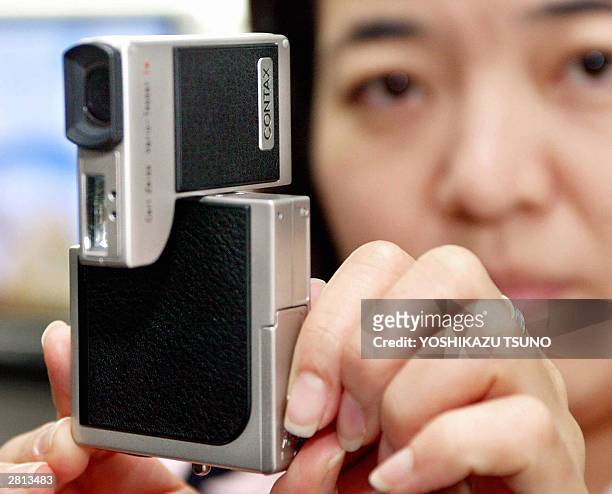 Japan's Kyocera, known as Contax brand employee displays the new digital camera "Contax SL300R", equipped with 5.8 - 17.4mm / F2.8 - 4.7 Carl Zeiss...