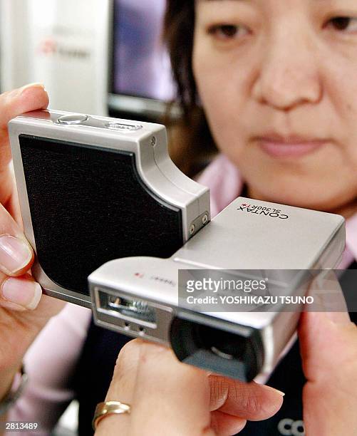 Japan's Kyocera, known as Contax brand employee displays the new digital camera "Contax SL300R", equipped with 5.8 - 17.4mm / F2.8 - 4.7 Carl Zeiss...