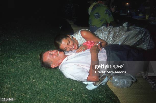 Hollywood film producer Leland Hayward shares a tender moment with his wife Slim at a party held in Honolulu for the cast of the film 'Mister...