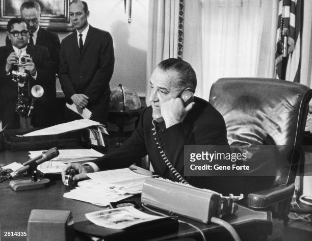 In his Washington office, US president Lyndon B. Johnson congratulates astronauts Virgil Grissom and John Young after their triple orbit of the...