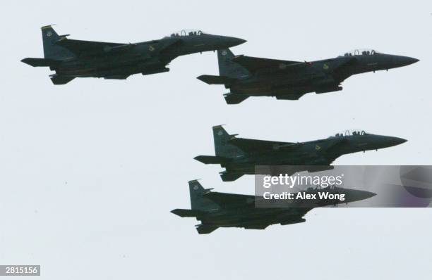Formation of four F15 fighter jets flies over the Wright Brothers Memorial December 16, 2003 in Kill Devil Hills, North Carolina. A re-enactment of...