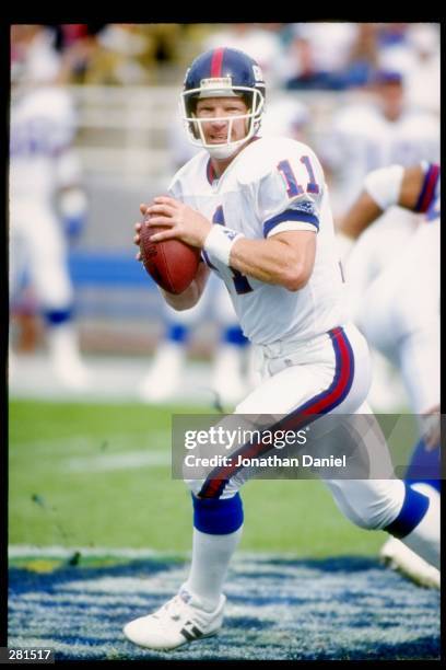 Quarterback Phil Simms of the New York Giants looks to pass the ball during a game against the Chicago Bears at Soldier Field in Chicago, Illinois....