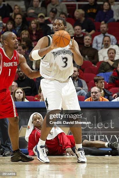 Oliver Miller of the Minnesota Timberwolves looks to pass the ball against Alton Ford of the Houston Rockets on December 16, 2003 at Target Center in...