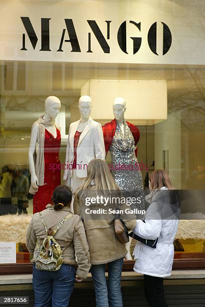 Three young women check out the display window of a Mango clothing store December 17, 2003 in Prague, Czech Republic. Retailers throughout Europe...
