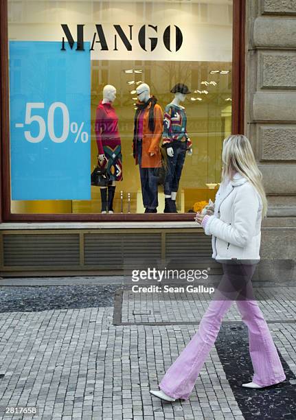 Young woman walks by a Mango clothing store offering pre-Christmas discounts December 17, 2003 in Prague, Czech Republic. Retailers throughout Europe...
