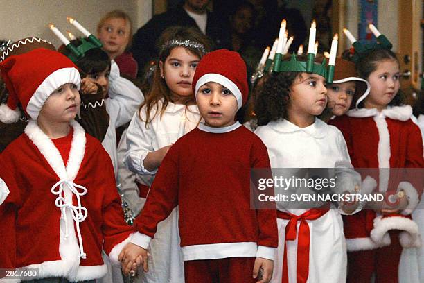 Swedish children dressed as Santa Lucia and Santa Claus celebrate Lucia Day in a Stockholm kindergarten 13 December 2003. St. Lucia is celebrated on...