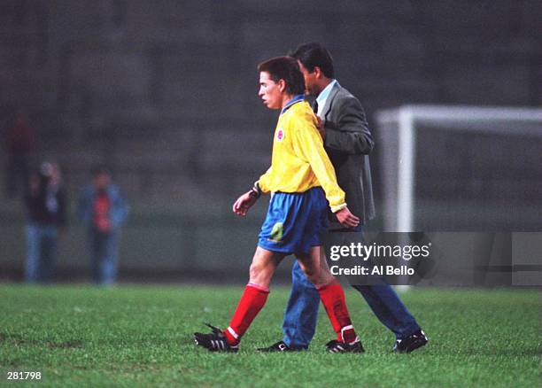 ARLEY BETANCOURT OF COLOMBIA IS LED OFF THE FIELD BY A MEMBER OF THE COACHING STAFF AFTER PUNCHING THE REFEREE, ROLAND GUITIEREZ CASTRO, FOLLOWING...