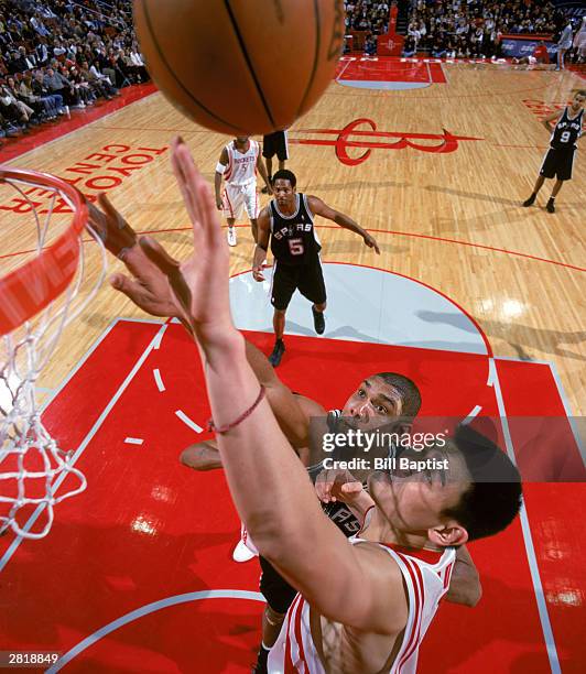 Tim Duncan of the San Antonio Spurs and Yao Ming of the Houston Rockets battle for a rebound during the NBA game at Toyota Center on December 11,...