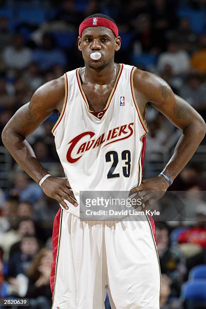 LeBron James of the Cleveland Cavaliers blows a bubble with his gum during the game against the Detroit Pistons at Gund Arena on December 11, 2003 in...