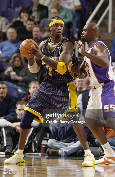 Jermaine O'Neal of the Indiana Pacers is defended by Jahidi White of the Phoenix Suns during the game at America West Arena on December 1, 2003 in...