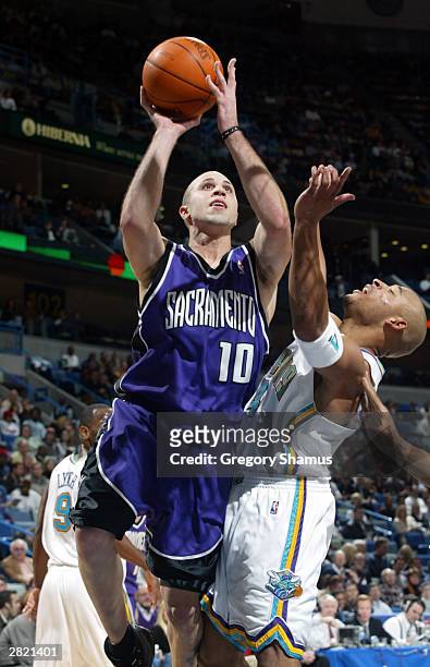 Mike Bibby of the Sacramento Kings attempts a shot against David Wesley of the New Orleans Hornets on December 18, 2003 in New Orleans, Louisiana....