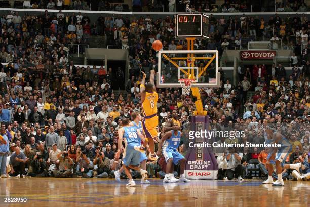 Kobe Bryant of the Los Angeles Lakers shoots and makes the game winning basket over the Denver Nuggets defense during the second half of action at...