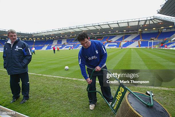 Birmingham City Manager Steve Bruce watches as a groundsman trys to clear the water-logged pitch before the FA Barclaycard Premiership match between...