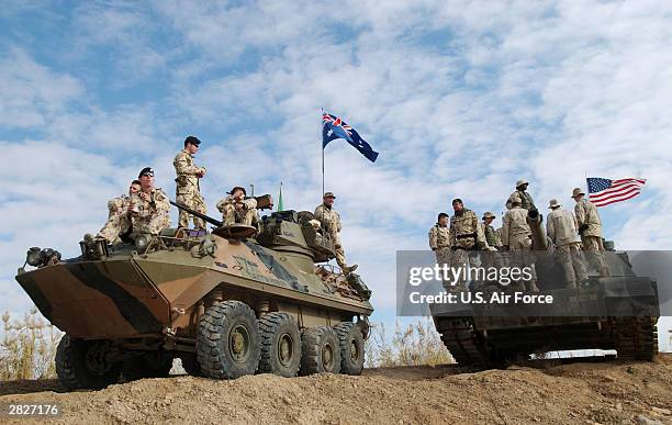 In this handout photo provided by the U.S. Air Force, Australian and U.S. Soldiers take in a World Wrestling Entertainment show from atop their...