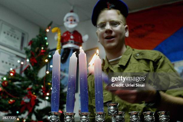 Israeli soldiers are seen lighting Hanukkah candles at an army base on December 22, 2003 in Rafah, Gaza Strip. Hanukkah celebrates the first major...