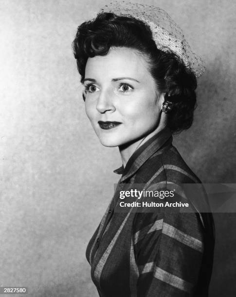 Headshot portrait of American actor Betty White wearing a veiled hat, circa 1955.