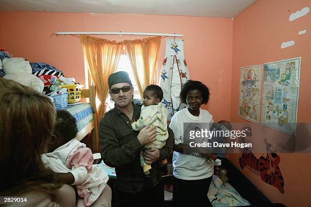 Singers Beyonce Knowles and Bono of U2 visit the Baphumelele Children's Home in Khayalitsha on December 5, 2003 in South Africa. The AIDS epidemic in...