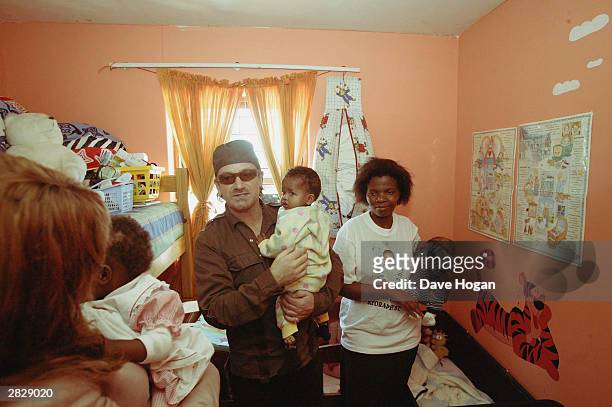 Singer Bono visits care worker Sylvia with the children inside the Baphumelele Children?s Home where there are upto 45 children orphaned by the HIV...
